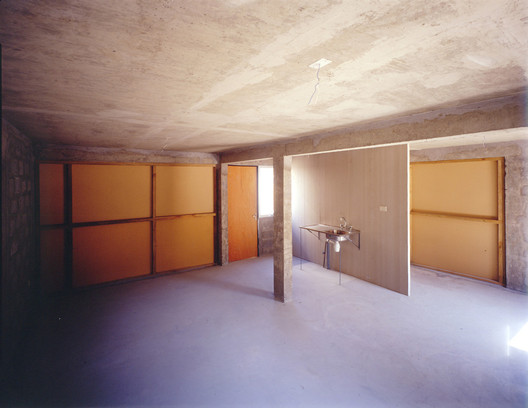 Delivered interior — bare concrete, orange panels, sink